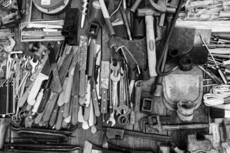 Ayudha Puja is collection of various tools like hammers, wrenches, knives, and pliers arranged on a wooden surface.